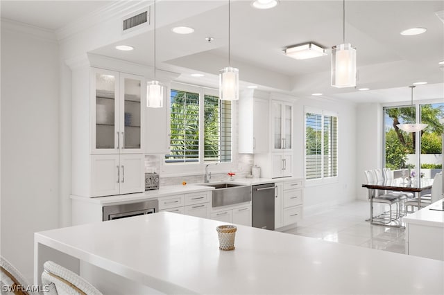 kitchen featuring dishwasher, pendant lighting, and white cabinets