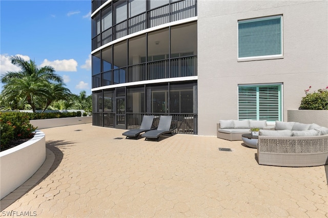 rear view of property featuring an outdoor living space, a patio, and a balcony