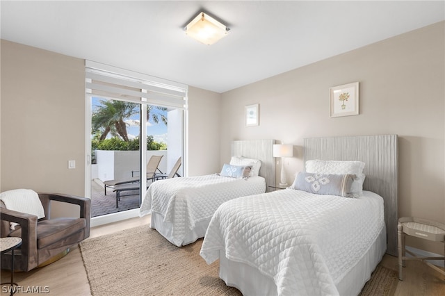 bedroom featuring access to exterior and light hardwood / wood-style flooring