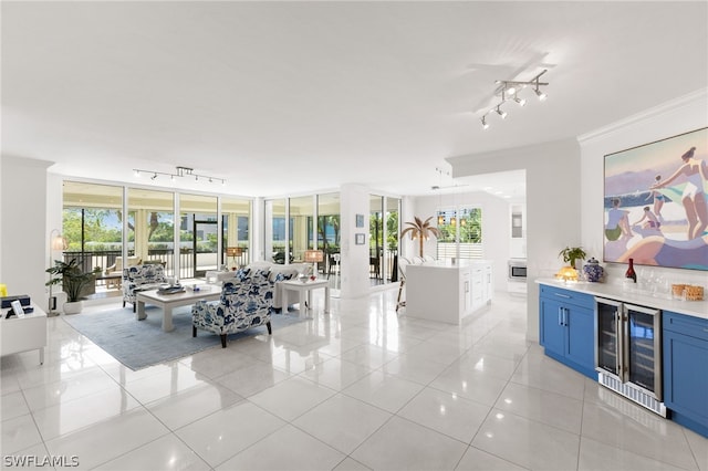 living room featuring bar area, a healthy amount of sunlight, light tile patterned floors, and wine cooler