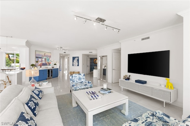 tiled living room featuring track lighting and ornamental molding