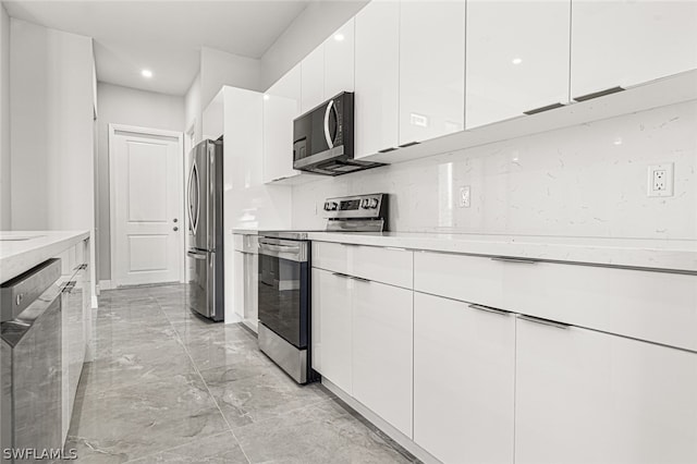 kitchen with white cabinets, stainless steel appliances, and light tile floors