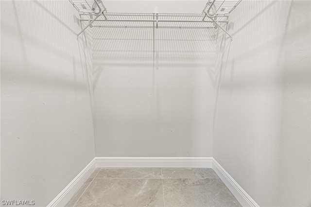 walk in closet with tile floors