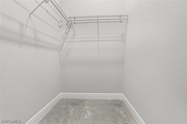 walk in closet with tile flooring