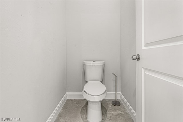 bathroom featuring toilet and tile floors