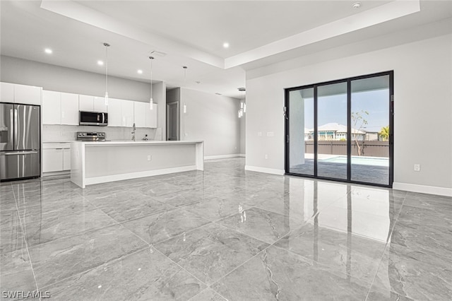 unfurnished living room featuring a raised ceiling and light tile floors