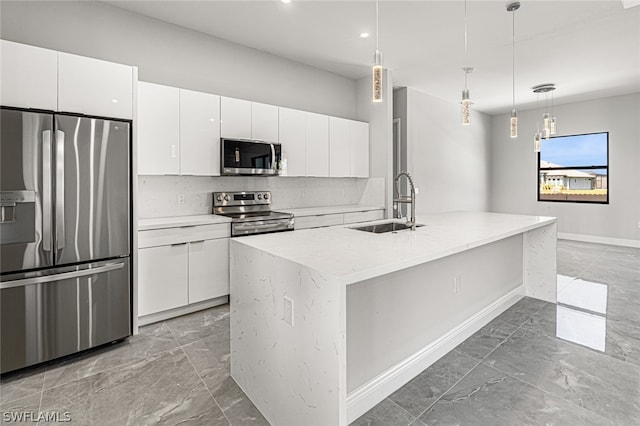 kitchen with white cabinets, appliances with stainless steel finishes, hanging light fixtures, and sink