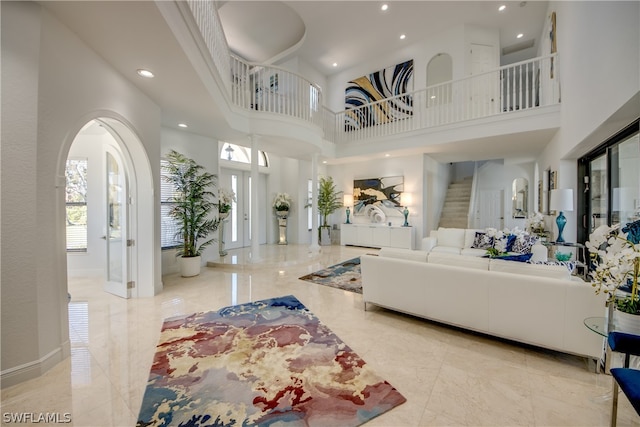 living room featuring light tile floors and a towering ceiling