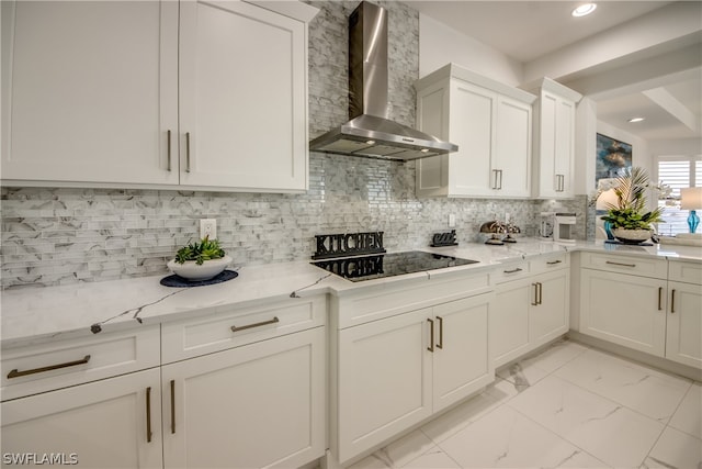 kitchen featuring backsplash, black electric cooktop, light stone countertops, and wall chimney range hood