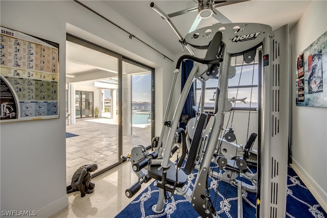 exercise area featuring ceiling fan and light tile flooring