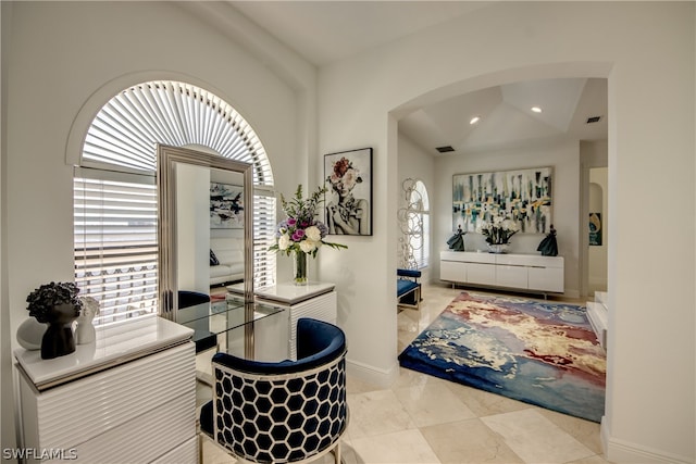 interior space featuring light tile flooring and vaulted ceiling