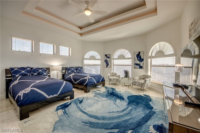 bedroom featuring a tray ceiling, multiple windows, and ceiling fan