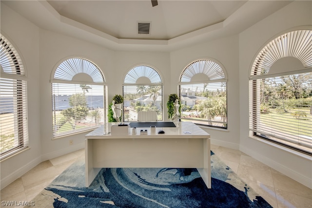 office area featuring light tile floors and a tray ceiling