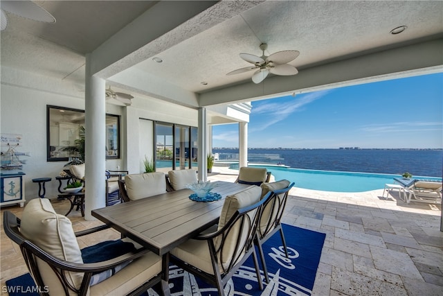 view of patio / terrace with a water view, an outdoor living space, and ceiling fan