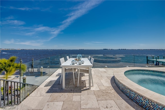 view of patio / terrace featuring an in ground hot tub and a water view