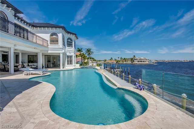 view of pool with a patio and a water view