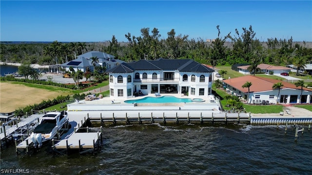 rear view of property with a balcony, a patio, a lawn, a water view, and a fenced in pool