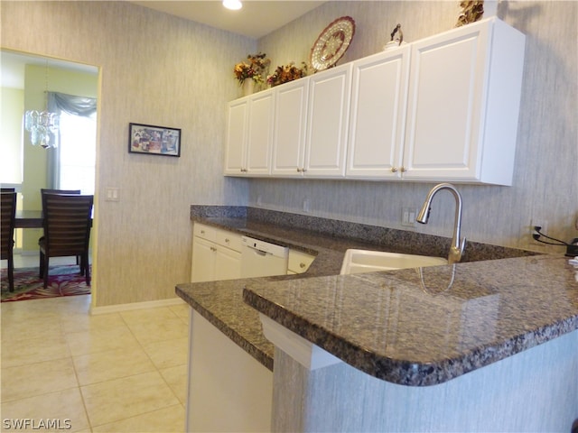 kitchen featuring white cabinetry, sink, kitchen peninsula, light tile patterned floors, and dishwasher