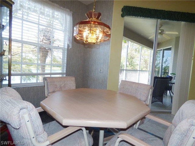 dining area featuring ceiling fan with notable chandelier