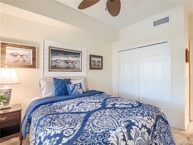 bedroom featuring ceiling fan, light carpet, and a closet