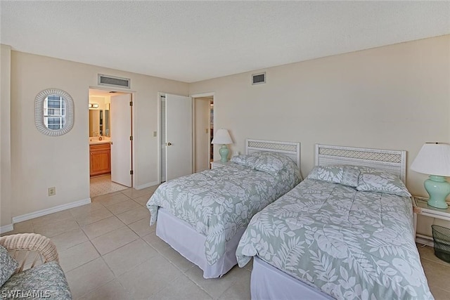 bedroom featuring light tile patterned floors, baseboards, visible vents, and a textured ceiling