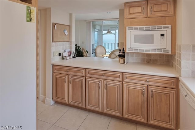 kitchen with tasteful backsplash, decorative light fixtures, white appliances, and light tile flooring