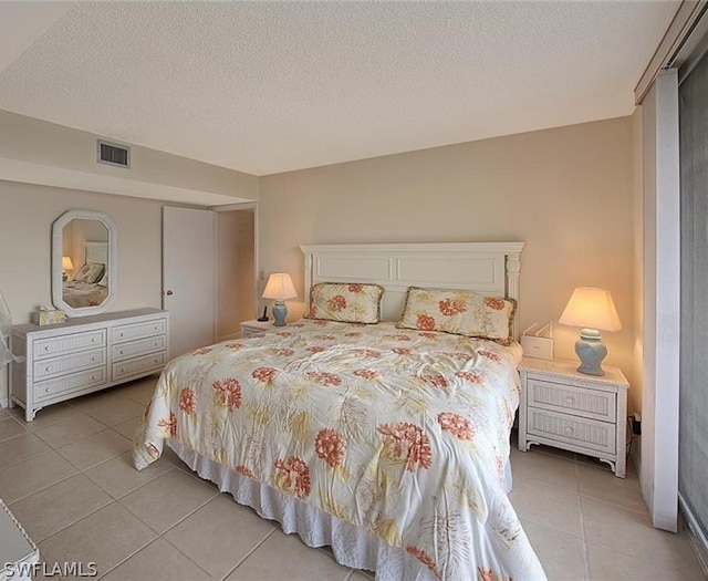 bedroom featuring light tile patterned floors, a textured ceiling, and visible vents