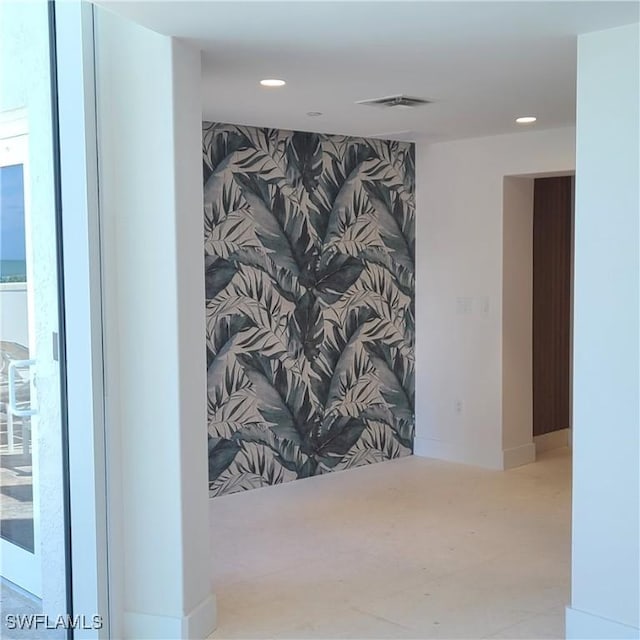 corridor with baseboards, an accent wall, visible vents, and recessed lighting