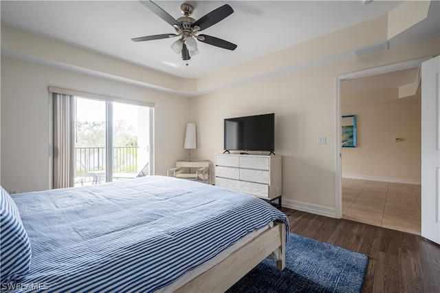 bedroom featuring a raised ceiling, access to outside, ceiling fan, and dark tile floors