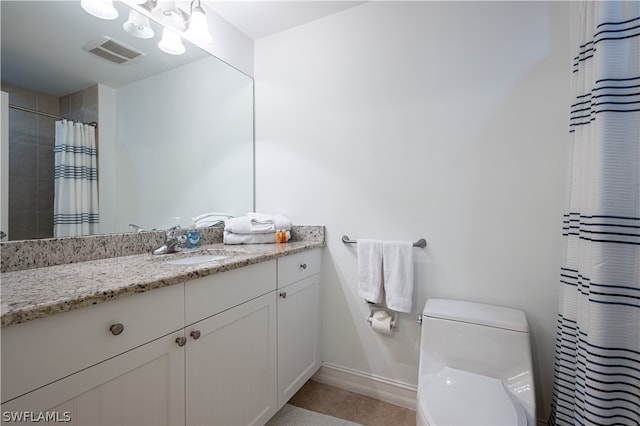 bathroom with toilet, tile floors, and vanity