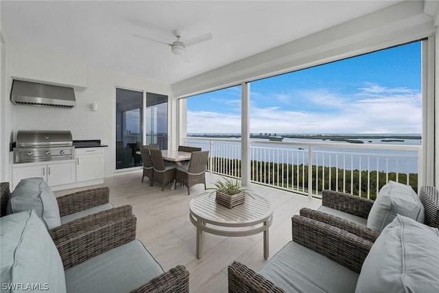 sunroom / solarium with a water view and ceiling fan