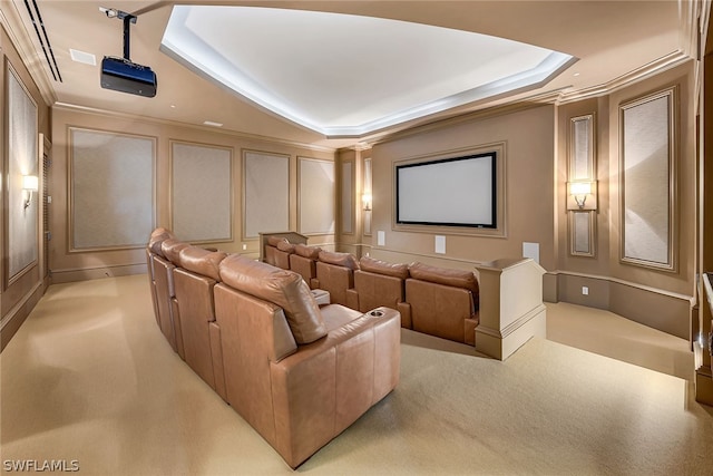 carpeted cinema room featuring a tray ceiling and crown molding