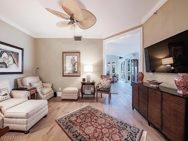 sitting room with baseboards, visible vents, a ceiling fan, crown molding, and light wood-type flooring