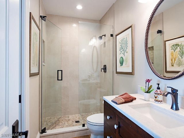 bathroom featuring recessed lighting, a shower stall, toilet, and vanity