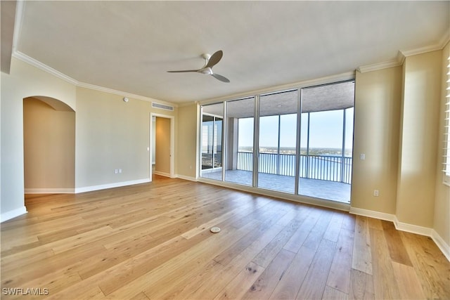 unfurnished room with a water view, crown molding, light hardwood / wood-style flooring, ceiling fan, and a wall of windows