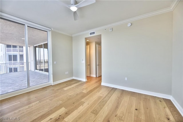 empty room with crown molding, light hardwood / wood-style flooring, expansive windows, and ceiling fan