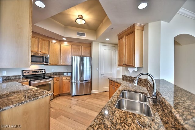 kitchen with sink, dark stone counters, and appliances with stainless steel finishes