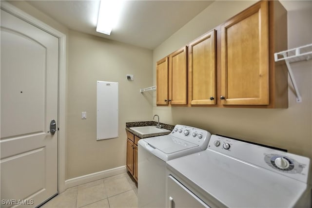 laundry area featuring cabinets, sink, light tile patterned floors, and washer and clothes dryer