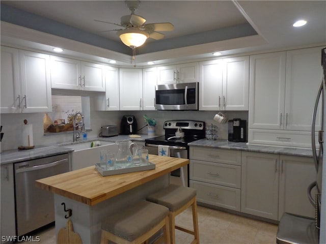 kitchen with white cabinetry, backsplash, ceiling fan, appliances with stainless steel finishes, and sink