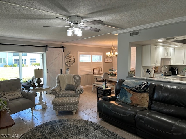 tiled living room with a barn door, ceiling fan with notable chandelier, a textured ceiling, and crown molding