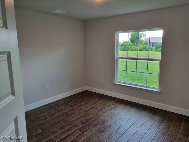 unfurnished room featuring dark wood-type flooring and plenty of natural light