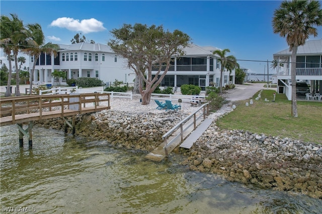 back of house with a sunroom and a water view