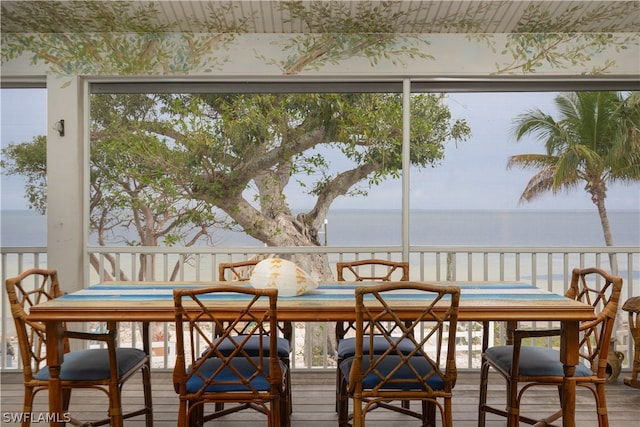 sunroom featuring a water view