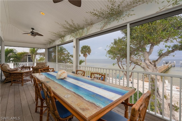 sunroom featuring a water view and ceiling fan