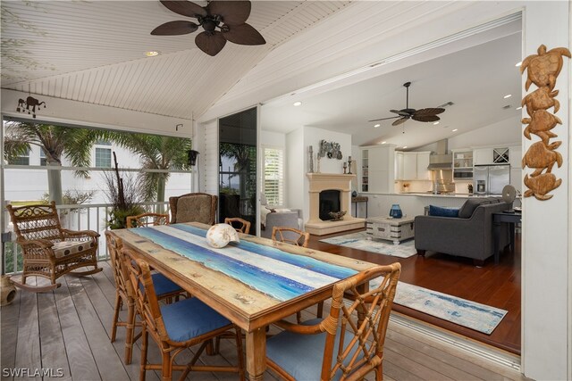 dining area featuring ceiling fan, high vaulted ceiling, and light hardwood / wood-style floors