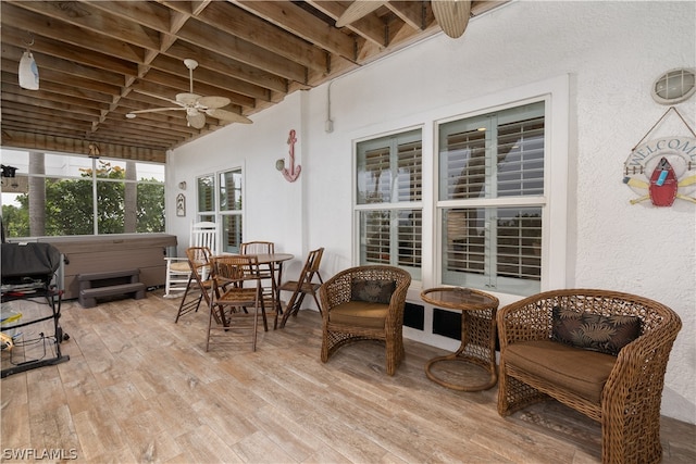 sunroom / solarium featuring beam ceiling and ceiling fan