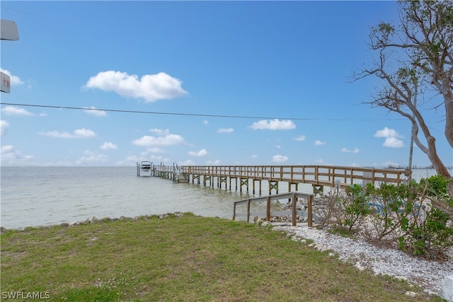 view of dock featuring a water view and a yard