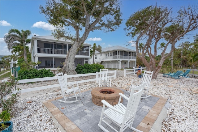 view of patio with an outdoor fire pit and a sunroom