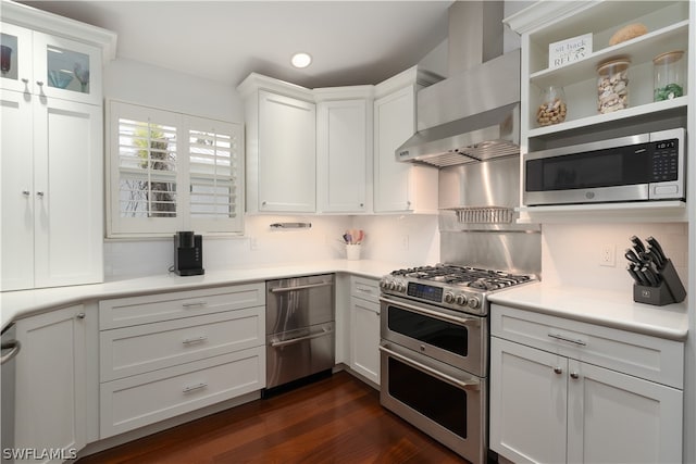 kitchen featuring stainless steel appliances, wall chimney range hood, white cabinets, and backsplash