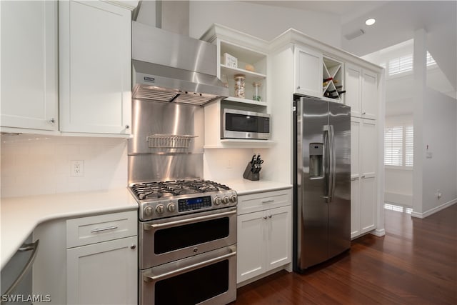 kitchen featuring dark wood-type flooring, appliances with stainless steel finishes, backsplash, extractor fan, and white cabinets